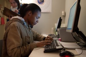 Estudiante del Programa de Vida Independiente usando una computadora en nuestro centro de recursos sin cita previa.