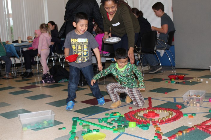 Родители и дети создают искусство мандалы в «Принесите музей на мероприятие Сообщества»