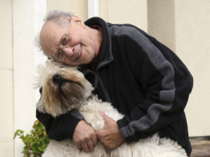 Старший мужчина с собакой