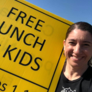 Impact NW Staff Member Holding Free Lunch Sign