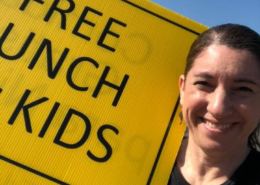 Impact NW Staff Member Holding Free Lunch Sign