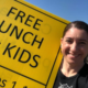 Impact NW Staff Member Holding Free Lunch Sign